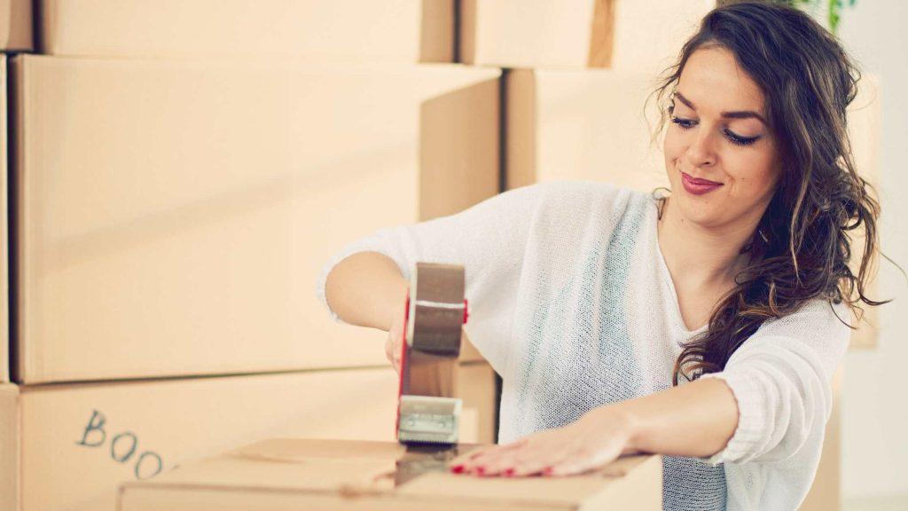 Lady packing her belongings in a box for storage