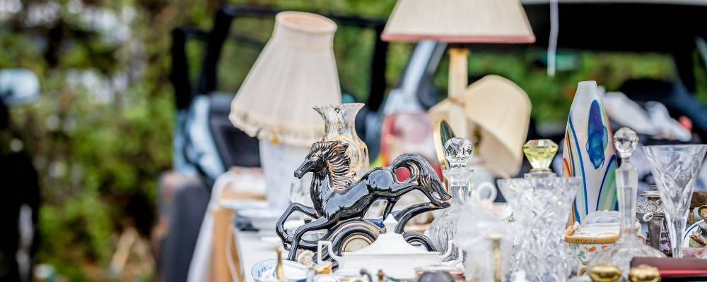 Table at a car boot sale with ornaments and lamps