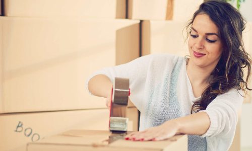 Lady packing her belongings in a box for storage