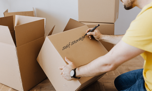 Man labelling self storage boxes for long term storage